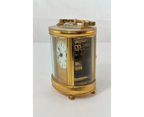 A modern carriage clock in oval case with circular enamelled dial and timepiece movement, height 11 cm 