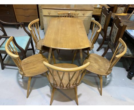 A 1960's Ercol light elm dining suite comprising drop leaf circular table, 5 stick back chairs and sideboard; a similar hoop 