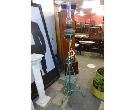 An Arts and Crafts painted wrought iron and copper floor standard oil lamp 