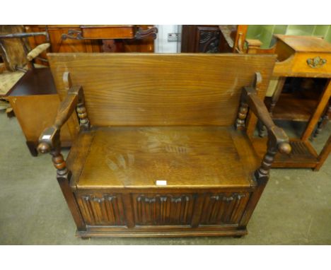 A carved oak linenfold monk's bench 