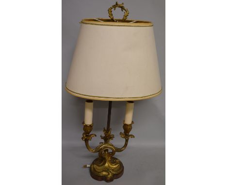  A 19th CENTURY FRENCH ORMOLU TWO BRANCH LAMP with acanthus mounts and oval shade on a wooden base 26ins high.