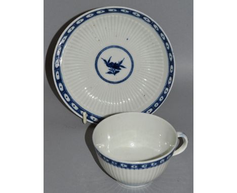 A WORCESTER HANDLED TEA BOWL AND SAUCER of finely ribbed form decorated with a central flower and cell border (28).