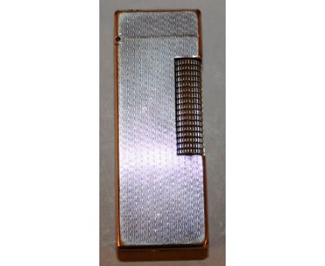 A SILVERED DUNHILL LIGHTER.