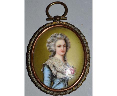 A CONTINENTAL OVAL PORCELAIN PORTRAIT PLAQUE of a lady in a metal gilt mount 2.5ins x 2ins.
