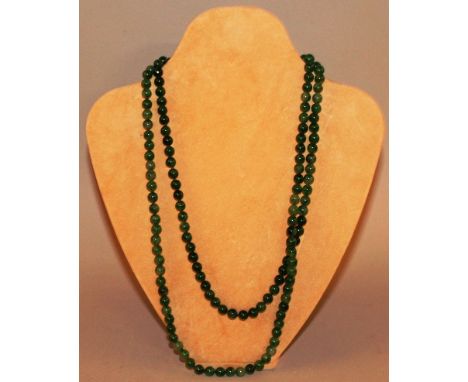 A GREEN JADE NECKLACE 48ins long.