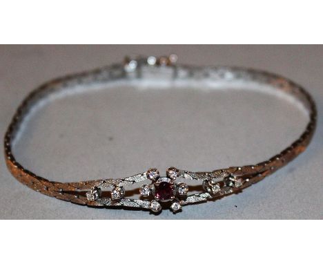 A 14CT WHITE GOLD DIAMOND AND RUBY SET BRACELET, stamped .585.