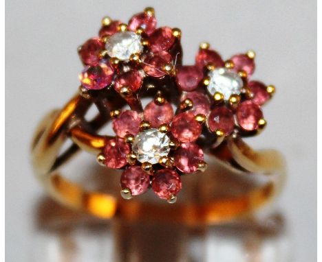 A RUBY AND DIAMOND TRIPLE FLOWER RING set in 18ct gold.