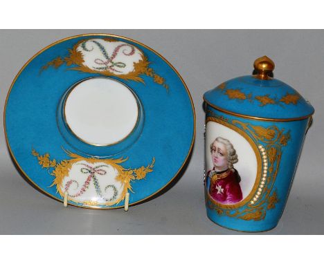 A SEVRES CHOCOLATE CUP, COVER AND STAND, blue ground edged in gilt and painted with portrait of lovers Sevres mark in blue.