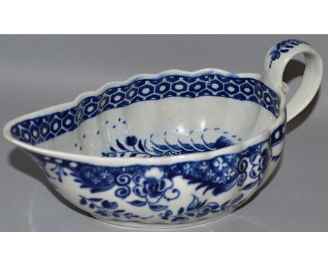 AN 18TH CENTURY WORCESTER SAUCEBOAT of ribbed form painted in blue under-glaze with a man on a bridge, pagodas and sailing bo