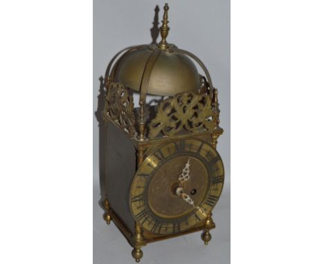 A GOOD BRASS LANTERN CLOCK with engraved dial striking on a large bell with pierced fretwork 14ins high.