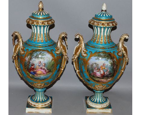 A SUPERB PAIR OF 19TH CENTURY SEVRES PORCELAIN TWO HANDLED URNS AND COVERS, light blue ground edged in gilt and painted with 