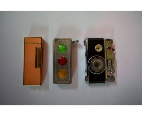 A novelty KKW camera lighter; together with a Dunhill apricot lacquer lighter; and another American traffic light example. 