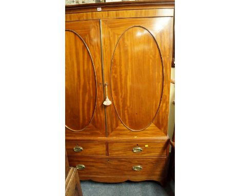 A George III mahogany and line inlaid linen press, the pair of oval panel doors now enclosing hanging space, 125.5cm wide. 