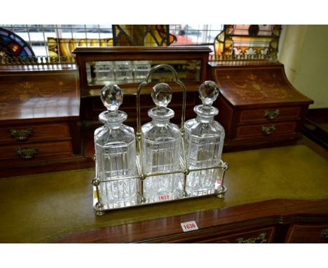 An electroplated three bottle decanter stand.