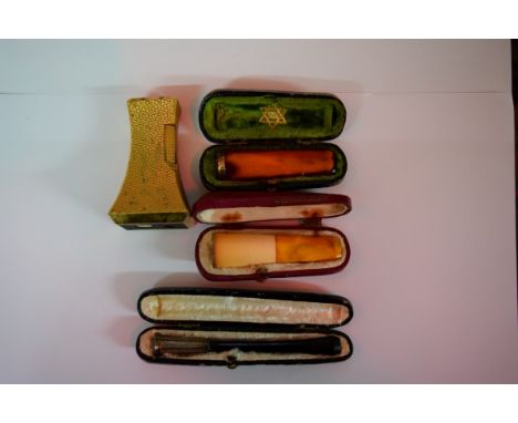 A Dunhill tapered gilt metal lighter, 7cm high; together with a cased amber and yellow metal mounted cheroot holder; another 