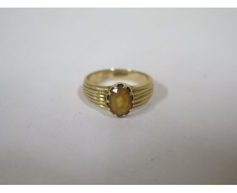 An 18ct gold ring inset with amber, approx 4.2 grams, size K, gold band in good condition, but some cosmetic wear to amber 