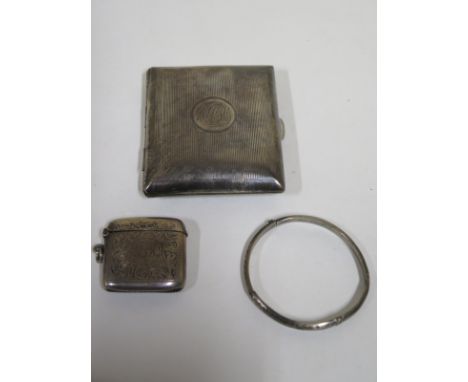 A silver cigarette case, Birmingham 1906 - together with a silver Vesta case, Birmingham 1911 - and a silver bangle, overall 