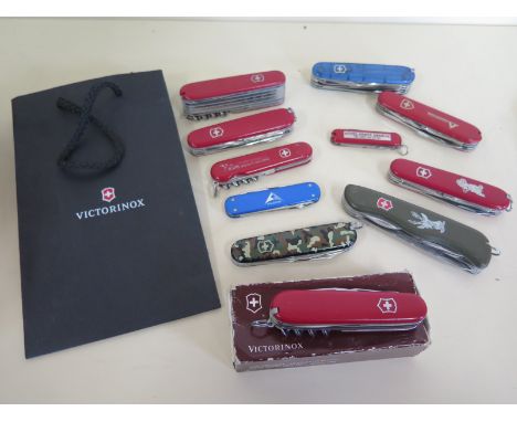 Eleven assorted Victorinox Swiss army knives plus a catalogue - generally in good condition but with some wear 