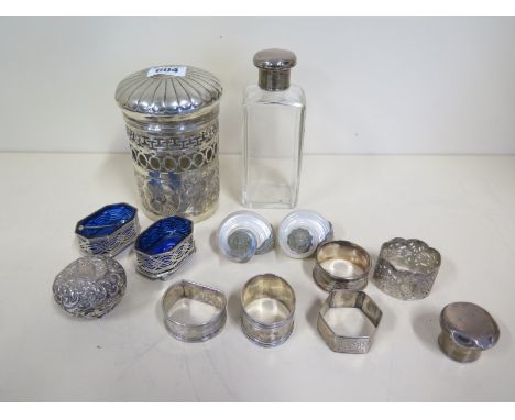 Four silver napkin rings, a plated ring, a pair of silver salts, two shells with white metal surrounds, a bottle with a silve