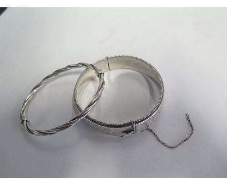 A silver bangle and a white metal bangle, total weight approx 1.2 toy oz, some wear consistent with age, chain broken to one 