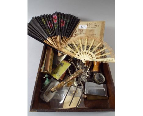 A Box of Curios to Include Cigarette Cards, Fans, Costume Jewellery, Compass, Lighters, Razors, Button Hooks Etc.  