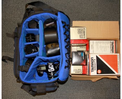 A Canon T90 single lens reflex camera and a groups of lenses with boxes.