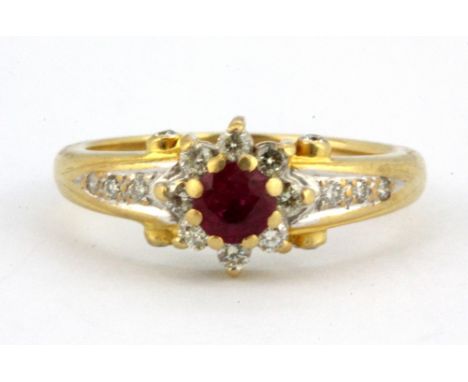 An 18ct yellow gold ring set with a centre ruby surrounded by diamonds (O.5), W. 4.7g.