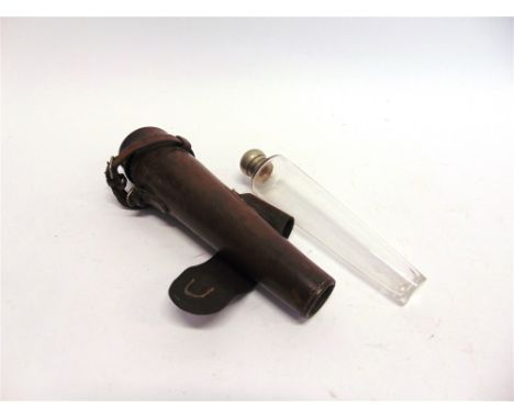 A CONICAL GLASS HUNTING FLASK with plated screw top contained in a leather holder for saddle mounting, length of holder 25cm