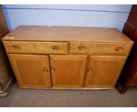 An Ercol light elm sideboard with two drawers over three panelled doors, 136 wide