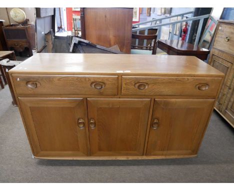 An Ercol light elm sideboard with two drawers over three panelled doors, 135cm wide
