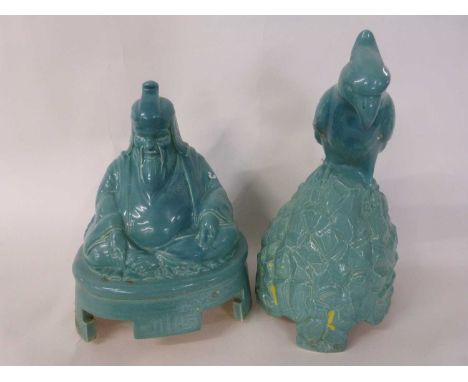 A pair of Royal Doulton green glazed speaker covers, one modelled as a parrot and the other as a Buddha, made for Artandia (s