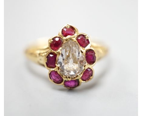 An early 20th century yellow metal and pear cut single stone diamond ring, with ruby set border, size O, gross weight 3.3 gra