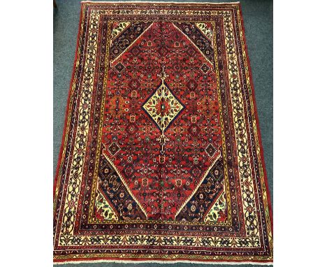 A Persian Hamadan rug / carpet, the central diamond-shaped medallion within a densely woven field of stylised motifs, and sim