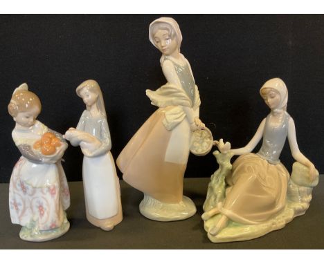 A Lladro lady, reclining with a bird, 17cm high, printed mark;  others, girl wit ha piglet, 17.5cm high;  girl with oranges, 