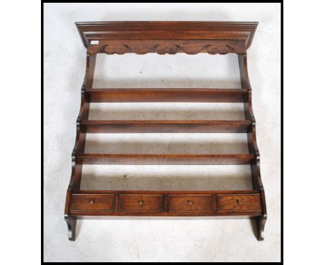 A good quality 18th century revival Ipswich oak hanging spice - plate rack having a shaped cornice over a series of plate she