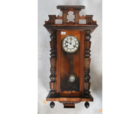 A Vienna-styled wall clock, walnut case with opening glazed door flanked by geometric decoration, surmounted by an architectu
