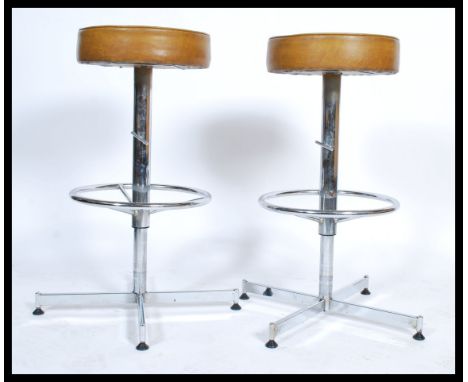 A pair of retro 1970's chrome and faux mustard / tan leather adjustable bar - kitchen stools with peripheral strechers, rise 