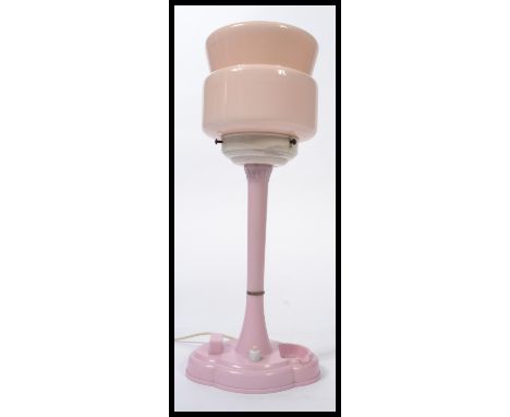 A vintage 20th century Art Deco bakelite bedside table lamp in a stunning pink colour way, raise on a circular pink base with