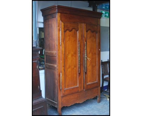 A 19th century French provincial chestnut armoire. The upright body with twin full length doors having brass hinges of polish