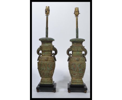 A pair of Chinese bronze table lamps of baluster form, geometric chased design raised on stepped ebonised bases it is 56cm in