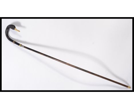 A vintage 20th century walking stick cane having a tapering wooden shaft with brass and silver white metal collar the handle 