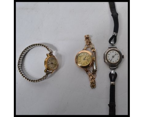 A group of three vintage watches - a sterling silver example with white enamel face and faceted hands , a yellow metal exampl