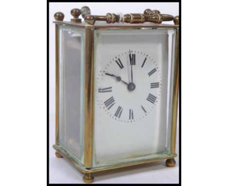 An early 20th century brass carriage clock with enamel dial, roman numeral chapter ring with faceted hands being with key