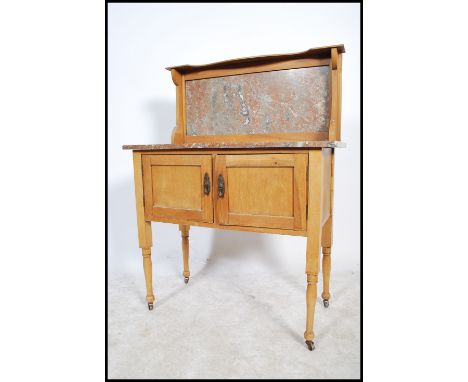 A 19th century satin walnut and marble topped wash stand, rouge marble top over panel doors raised on block and turned legs o