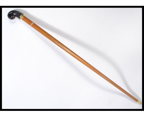 A vintage 20th century walking stick cane having a tapering wooden shaft with brass collar and shaped rams horn knop. Measure