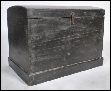 A vintage 20th century dome top ebonised trunk. Constructed from elm panels with hinged dome top raised on a plinth base.