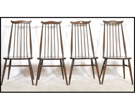 A set of four 20th century vintage Ercol beech and elm stick back dining chairs