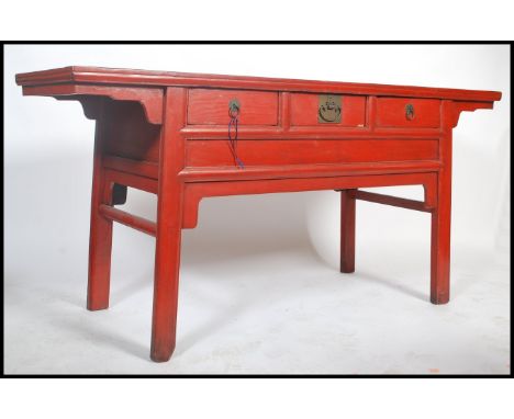 A 20th century large Chinese red lacquered sideboard / console table believed to be from the north east region possibly Dongb