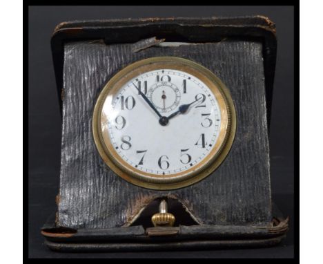 An early 20th century / Victorian travelling leather cased pocket watch clock having a white enamel face with faceted hands a
