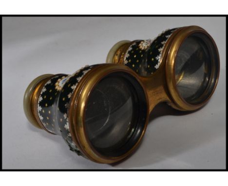 A pair of 19th / early 20th century opera glasses having black enamel decoration with cartouche panels with floral sprays and